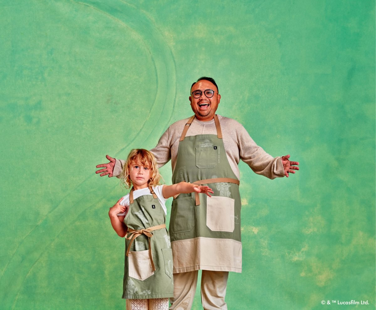 An adult and a child wearing Grogu aprons